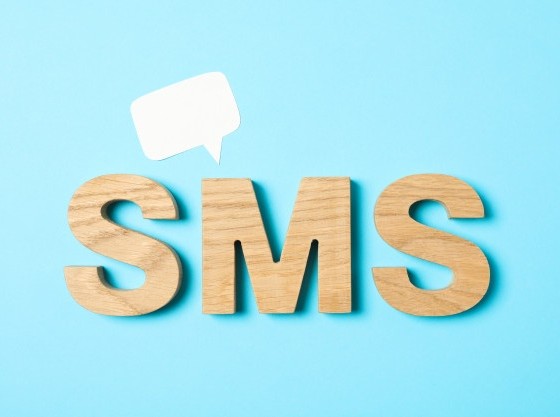 sms-word-made-from-wooden-letters-on-blue-background_185193-98